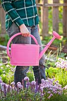 Woman carrying a watering can.