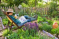 Woman relaxing in kitchen garden.