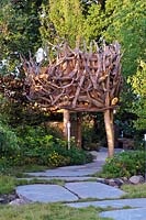 The Zoflora and Caudwell Children's Wild Garden. Tree house made from driftwood. Designers: Adam White and Andree Davies, Sponsors: Zoflora. RHS Hampton Court Palace Flower Show 2017