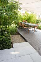 Small city garden with contemporary terrace, sun sail and Acer