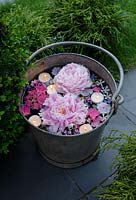 Candles floating in a vintage metal bucket with Peonies, Hydrangea, Jasmine and Campanula