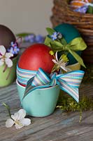 Decorated dyed Easter eggs with ribbon, dainty flowers and string