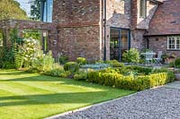 A courtyard garden designed by Louise Harrison-Holland. Planting includes clipped box hedging, Hydrangea paniculata, Eryngium, Japanese anemones and Stachys