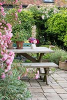 Seating outside the kitchen, with Sweet Peas and Dahlias in a vase from the garden