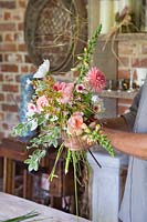 Man arranging a bouquet with Dahlias, Rosa, Digitalis and foliage