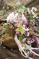 Mixed floral arrangement placed on tree trunk