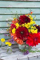 Glass vase with bouquet from flowers picked in the garden. Dahlia 'Mrs Eileen', 'Babylon Red', 'Mingus Alex', Helenium and Crocosmia