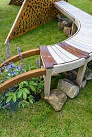 Oak bench and corten steel screen detail with planting of blue Eryngium and Festuca glauca grasses. Curves and Cube - RHS Chatsworth Flower Show 2017 - Designer, Builder, Sponsor: Gaze Burvill and David Harber