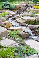 Waterfall. Naturalistic Water Garden - Jackie Knight's Just Add Water - RHS Chatsworth Flower Show 2017. Designer: Jackie Sutton - Built and sponsored by: Jackie Knight Landscapes