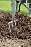 Manure on soil with fork
