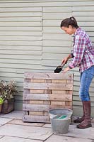 Woman filling in pallet with additional compost