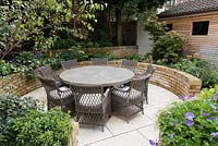 Late Summer garden with seating area and raised beds 