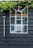 Garden shed with hanging fork.