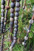 Vertical poles of pods and beads shoot through bamboo in sculptor and ceramicist Marcia Donahue's garden in Berkeley, California.