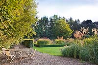 View of the garden in October: relaxing area and autumn borders.