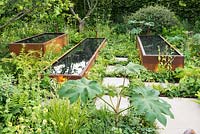 Rusted water troughs set in lush green planting - BBC Radio 2 Feel Good Gardens - The Zoe Ball Listening Garden, RHS Chelsea Flower Show 2017 - Designer:  James Alexander-Sinclair