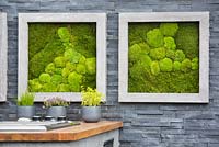 Living pictures with moss in stone frames and herbs in pots in the outdoor kitchen against modern black slate stone wall in the outdoor kitchen. Contemporary Bee and Butterfly Garden -
 BBC Gardeners World Live Flower Show 2017
