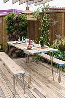 Table set for meal outside - in BBC Gardener's World Live, Birmingham 2017 -  Living Gardens 'Its Not Just About The Beardâ€¦' Garden - Designer : Peter Cowell and Monty Richardson, Living Garden - Gold