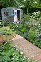 Brick paving and caravan with mixed herbaceous borders, A Celebration of Caravanning, RHS Chelsea 2012.