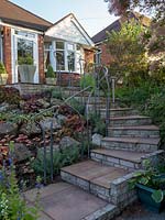 The front garden is up a steep incline and the curved path and steps have artistic handrails to assist the ascend.  A large bed with rocks is planted with a colourful collection of Heuchera