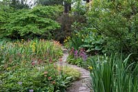 The Water Garden at Newby Hall, its paths edged in Harlow Carr candelabra primulas. The pool is enclosed in beds of Gunnera, Rheum, Arum and flag Irises.