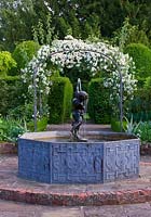 Lead pool with Cherub fountain and metal arch with Rose 'Snowdrift'