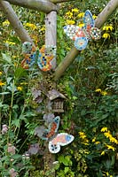 Mosaic 'butterflies' and insect house on wooden pergola