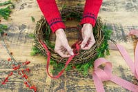 Tying a tape handle to a festive wreath