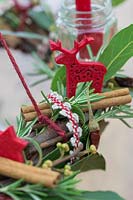 Close up detail of red themed advent candle holder centerpiece with felt reindeer