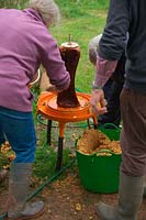 Hydropress pressing system that uses mains water pressure to extract high levels of juice from milled apples and pears in use at Community apple juicing day in Sampford Peverell, Devon, late October - assembling the mill