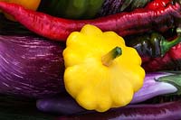 Freshly harvested colourful vegetables - summer patty pan squash, aubergines and romano peppers
