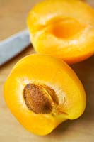 Sliced apricot (Prunus armeniaca), table top, knife