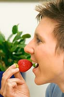 Young lady eats strawberry