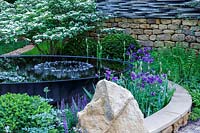 RHS Chelsea Flower Show 2014.  The 'Tour De Yorkshire' garden, designer Alastair W Baldwin, sposor Yorkshire.com. Large reflecting 'dish' pond. 