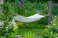 Hampton Court Flower Show, 2004. 'Lazy Days' ( des. Pete Simms ) hammock in informal and natural garden