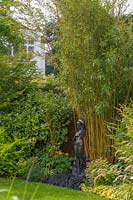 18 Queens Gate, Bristol, UK ( Sheila White ) small town garden in summer. statue of woman and Bamboo covering fence