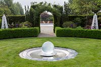 Mitton Manor, Staffordshire. Glass water feature sphere in circular garden lawn