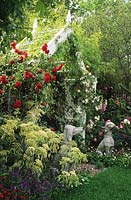 Chelsea FS 1997 Design Julian Dowle Rose covered seat with climbing roses and dog statues Cornus controversa Variegata