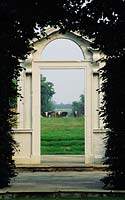 Butterstream County Meath Ireland Trompe l oeil door at end of garden looking out to landscape beyond with cows