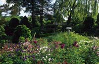 Gardener s Cottage West Dean Sussex shady garden with Aquilegias Alliums and sculptural sundial