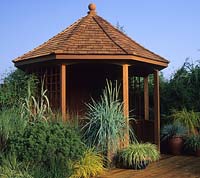 Hampton Court FS design Geoff Whiten wooden summer house with ornamental grasses in containers