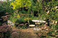 Five Oaks Sussex Table and chairs in gravel garden Pimpinella major Rosea Robinia Frisia