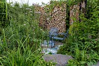 Rhe Viking Cruises: The Art of Viking Garden at RHS Chelsea Flower Show 2019. Looking into the garden that is enclosed by stack of sawn timbers. Designer: Paul Hervey-Brookes Sponsors: Viking. 
