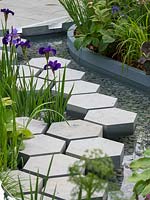 The Manchester Garden. The hexagonal and rectacular paving adds interest to the water feature and contrast well with the gravel in the water feature.  - Designer: Exterior Architecture. RHS CHelsea Flower Show 2019