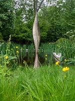 The Savills and David Harber Garden is a green garden depicting a sustainable woodland clearing, with sculpture and central water feature. Designed by Andrew Duff, Sponsored by David Harber Savills, RHS Chelsea Flower Show, 2019.
