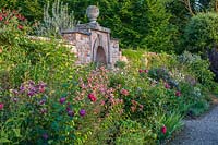 Walled kitchen garden Lilium speciosum 'Black Beauty' and Clematis viticella 'Emilia Plater' - Morton Hall Gardens, Worcestershire