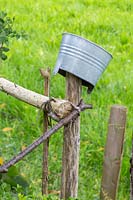 A metal bucket on top of a wood stake helps to protect against rot. 