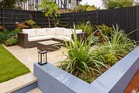 An outdoor sofa and chairs and built-in seating with rendered brickwork. 