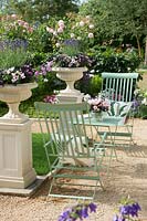 Green table and chairs in classic garden at RHS Hampton Court Palace Flower Show 2015.

