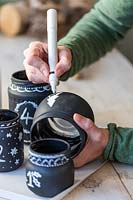 Using white marker pen to decorate black painted glass jars
